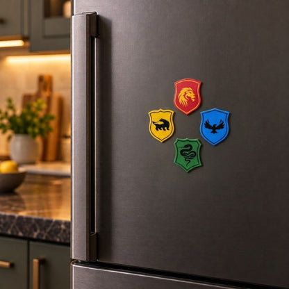 Four colorful shield-shaped refrigerator magnets with black animal silhouettes are displayed on a dark gray stainless steel fridge in a kitchen setting.