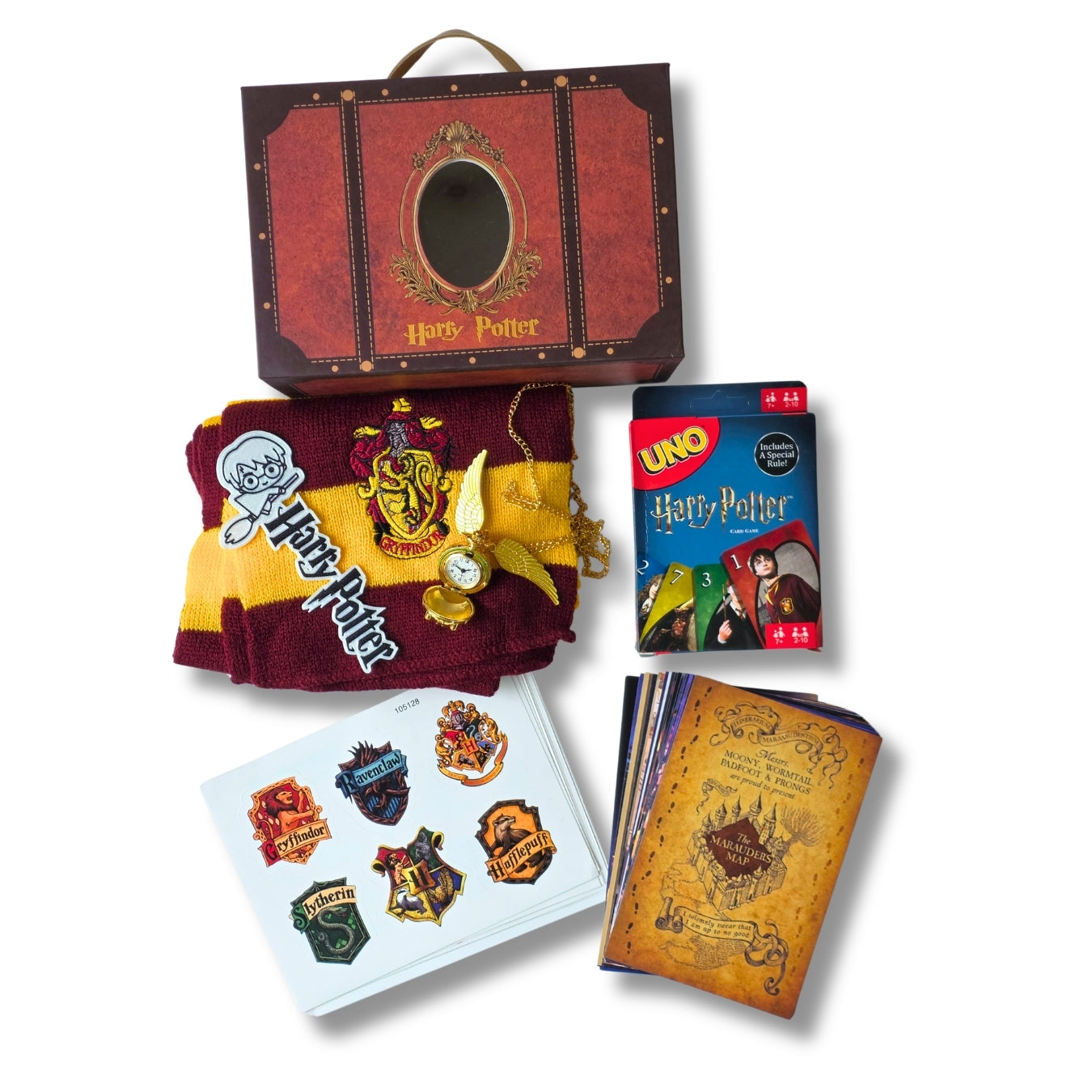 Harry Potter themed gift set featuring a red and brown trunk-shaped box, a maroon and gold Gryffindor scarf with a clock charm, a pack of Harry Potter UNO cards, temporary tattoos, and a notebook with an aged map cover, all arranged on a white background.
