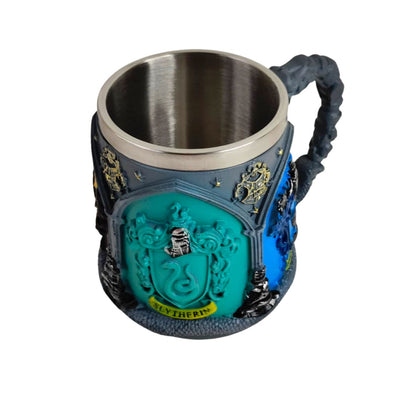 A Slytherin themed stainless steel mug with a textured dark gray and blue body, featuring a prominent teal Slytherin crest on the front and a twisted handle.