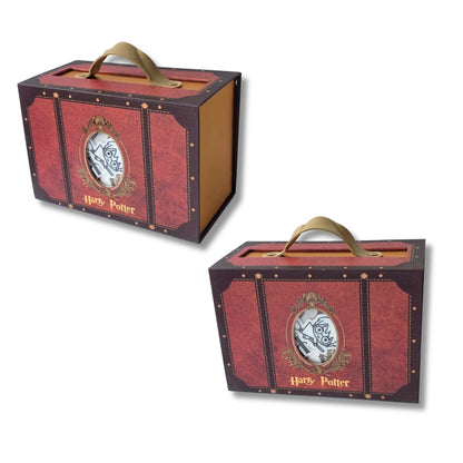 Two red and brown Harry Potter trunk-shaped coin boxes with gold handles and decorative gold trim, shown on a white background.