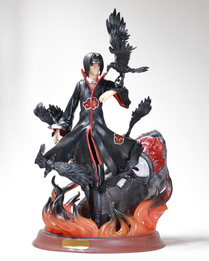 A detailed PVC figure of Itachi Uchiha from the anime Naruto, depicting the character in a dynamic pose with a bird and flames in the background.